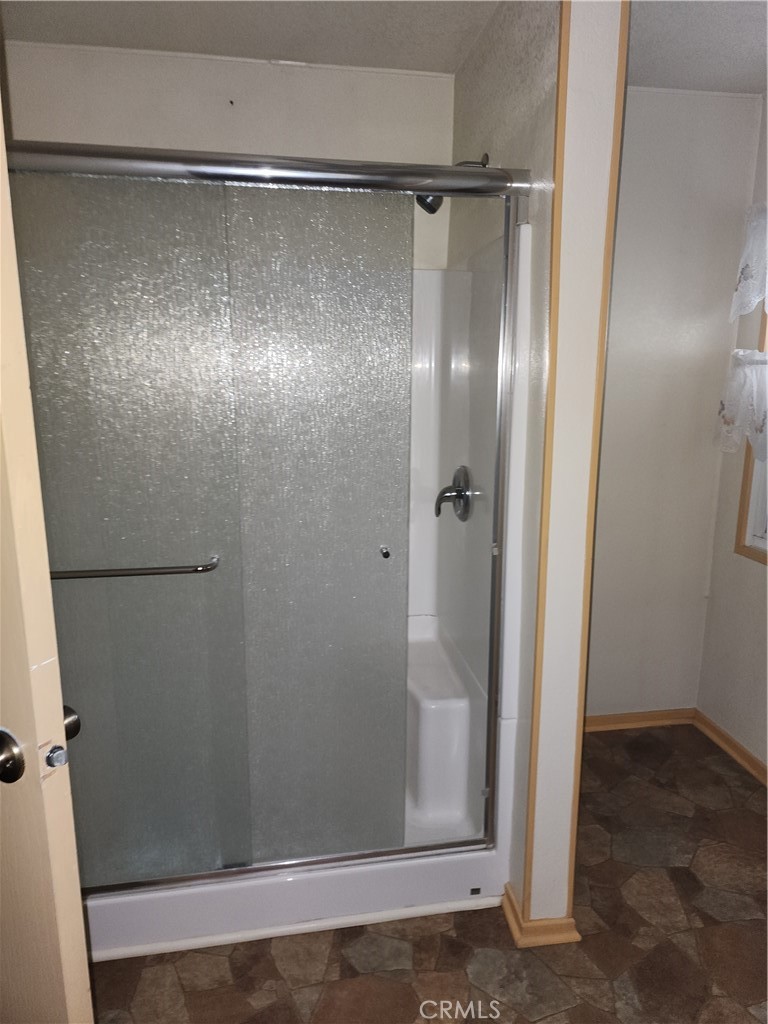 13393 Mariposa Road, Unit 181 Victorville, CA 92395 - Photo 6 of 19 a bathroom with a glass shower door