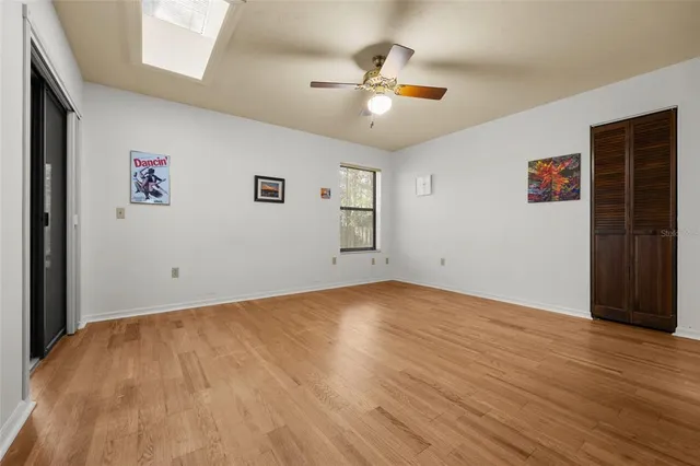 a view of a livingroom with wooden floor and a ceiling fan