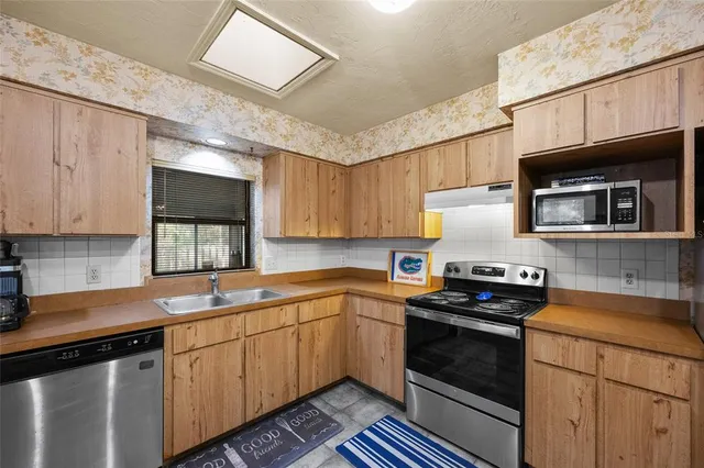 a kitchen with stainless steel appliances a stove sink microwave and cabinets