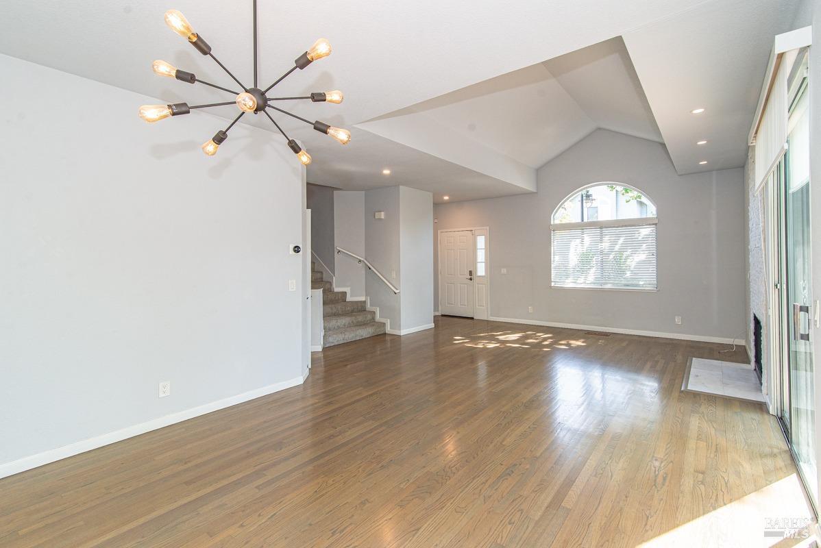 23 Baypoint Drive San Rafael, CA 94901 - Photo 7 of 40 an empty room with wooden floor fan and windows