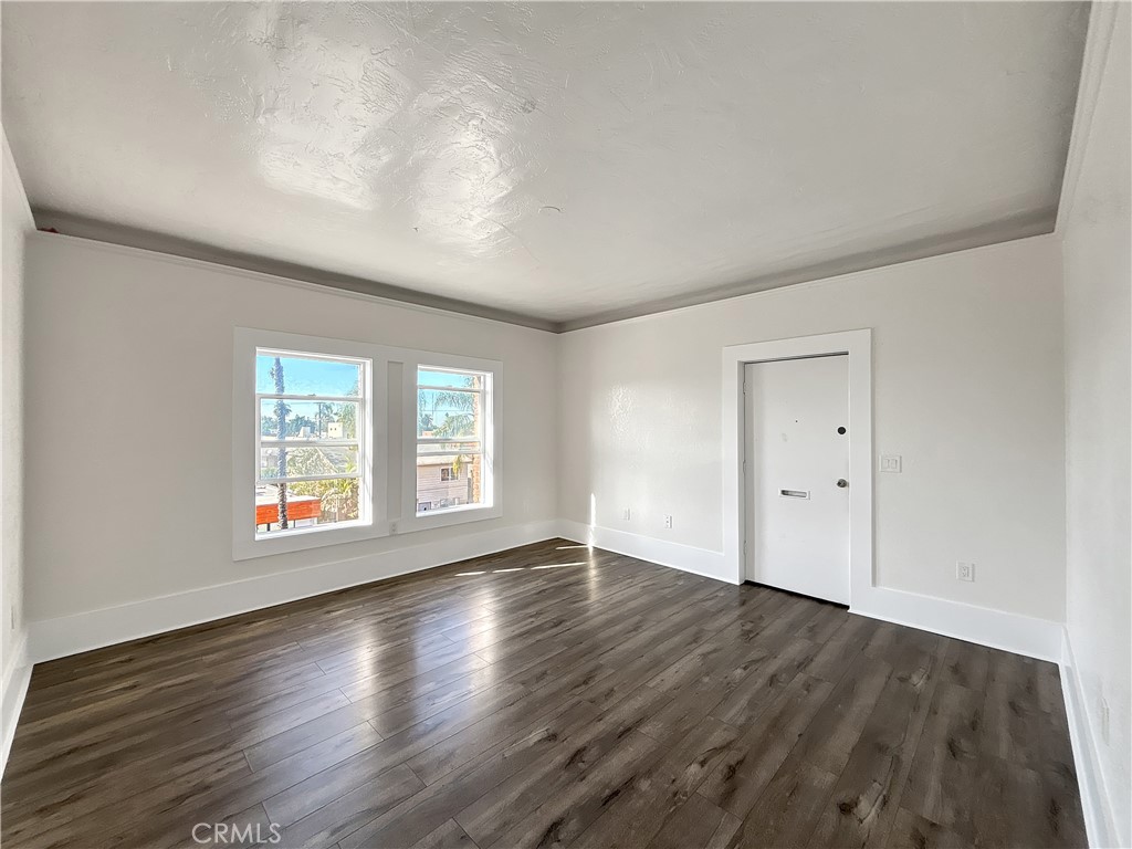 800 Pacific Avenue, Unit 300 Long Beach, CA 90813 - Photo 12 of 20 an empty room with wooden floor and windows