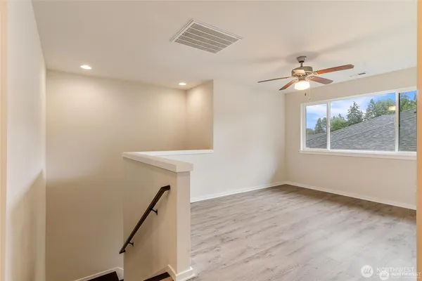 a view of a kitchen with wooden floor and a ceiling fan