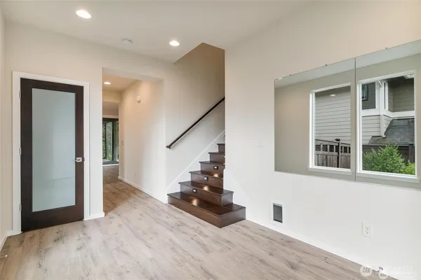 a view of kitchen with stainless steel appliances kitchen island wooden floor dining table and chairs