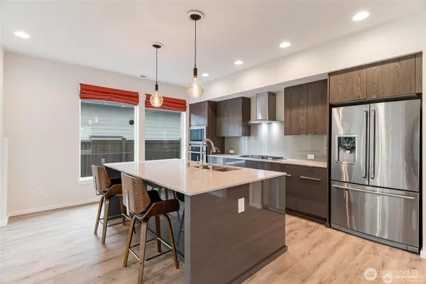 a kitchen with stainless steel appliances a stove a sink and a refrigerator