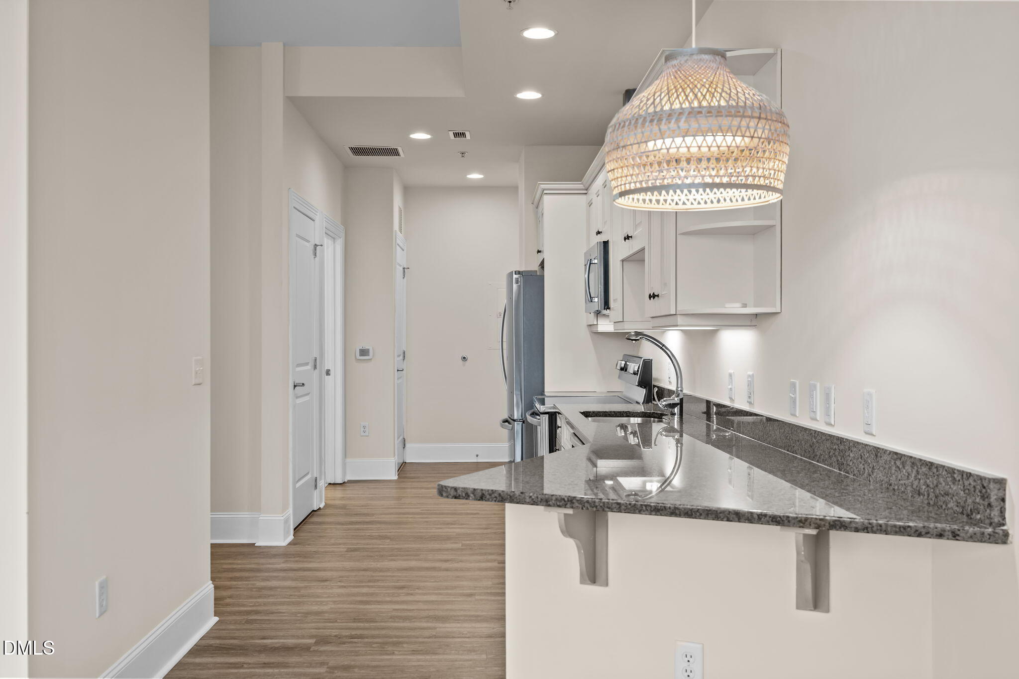 400 West North Street, Unit 814 Raleigh, NC 27603 - Photo 19 of 45 a kitchen with stainless steel appliances granite countertop a sink a stove and a wooden floors