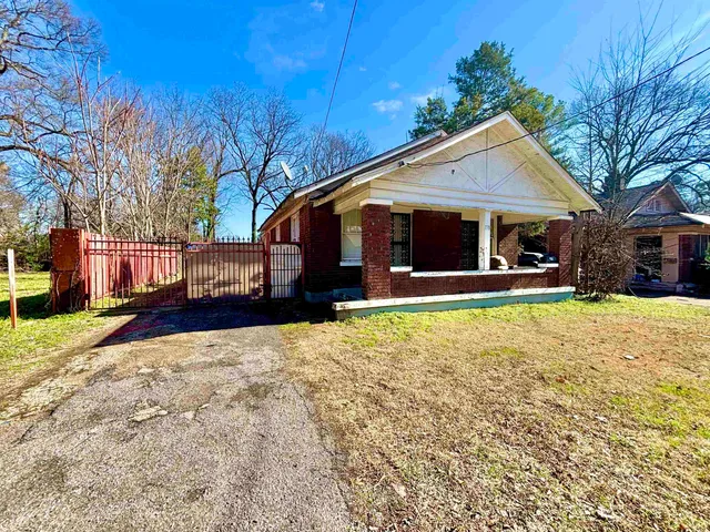 a front view of house with yard and trees in the background