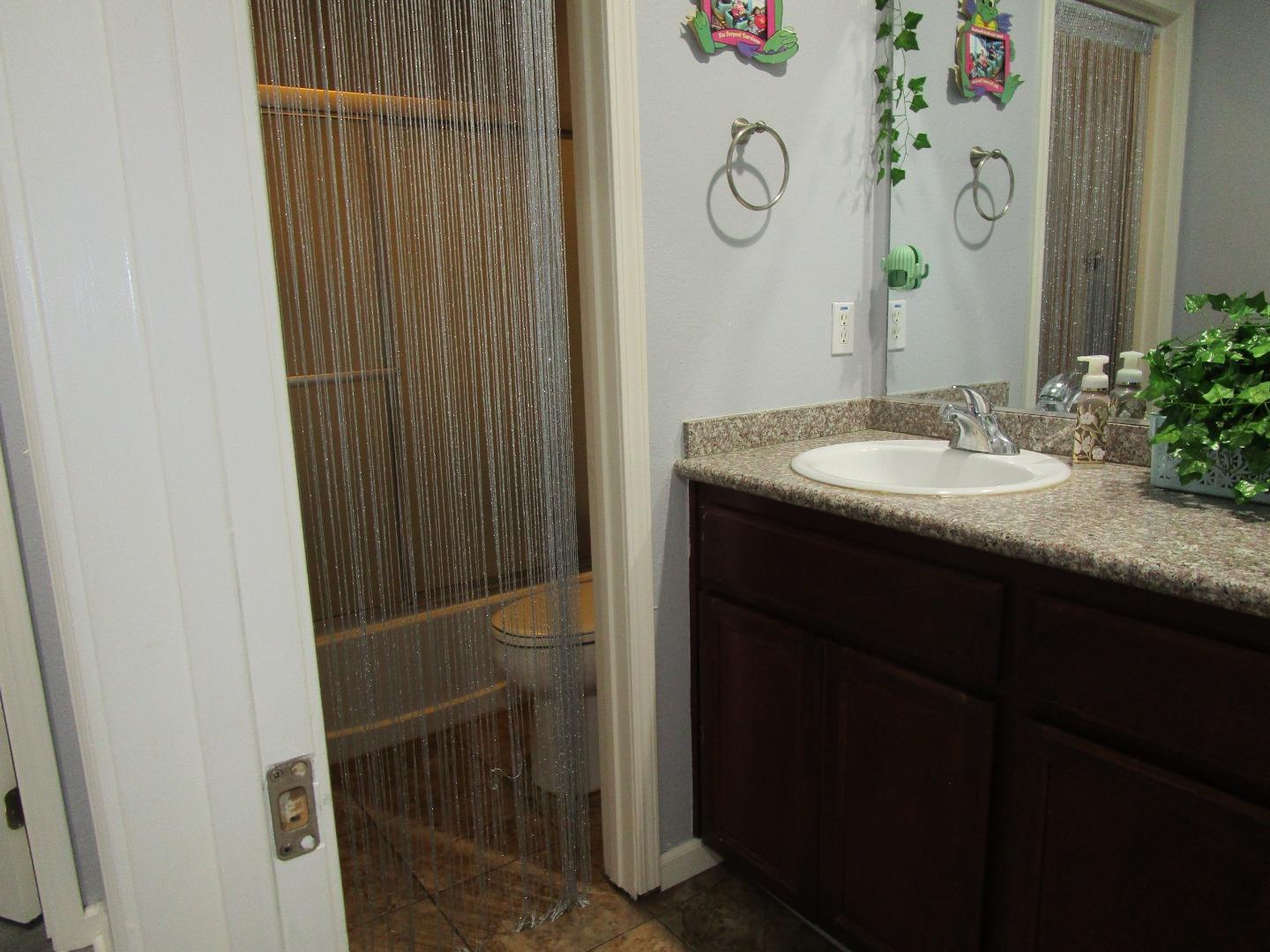 413 Hydrangea Court Merced, CA 95341 - Photo 13 of 16 a bathroom with a granite countertop sink and a mirror