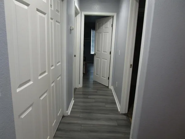 a view of a hallway with wooden floor and staircase