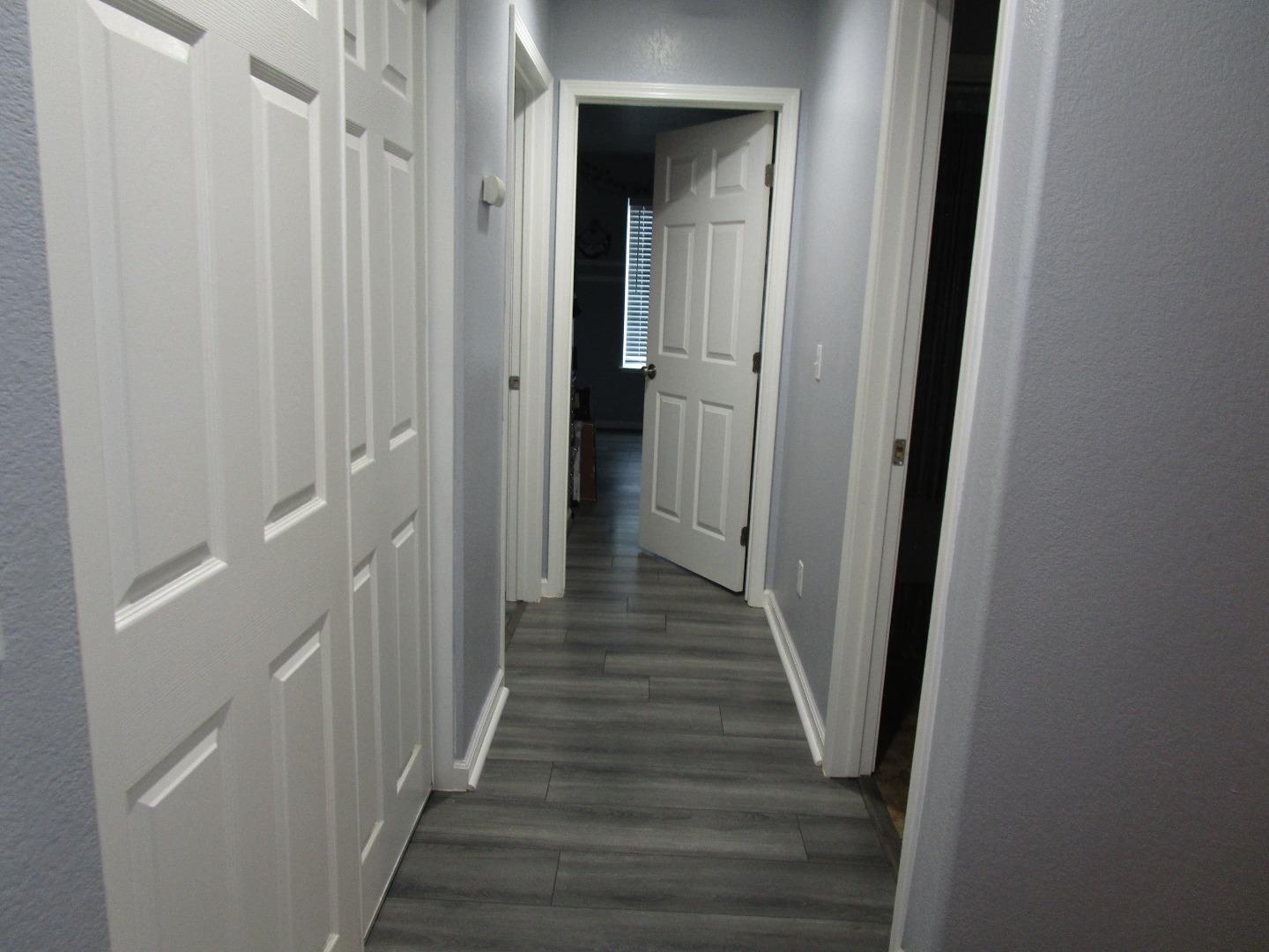 413 Hydrangea Court Merced, CA 95341 - Photo 14 of 16 a view of a hallway with wooden floor and staircase