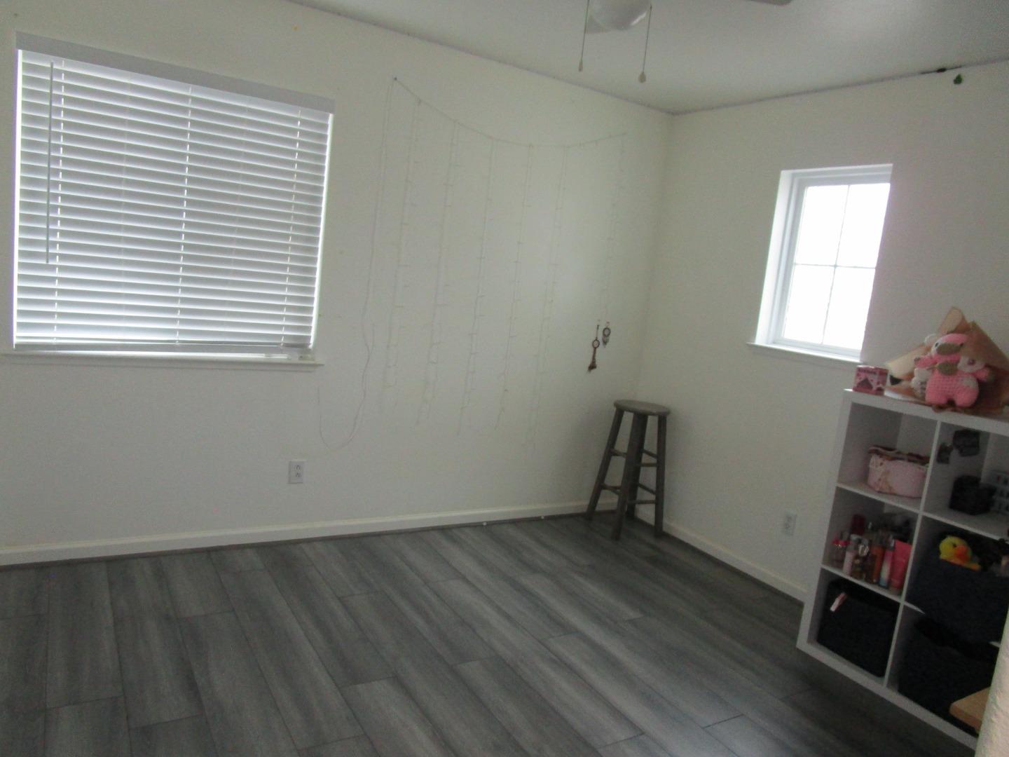 413 Hydrangea Court Merced, CA 95341 - Photo 10 of 16 an empty room with a wooden floor and a window