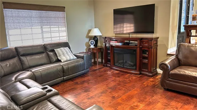 a living room with furniture a flat screen tv and a fireplace