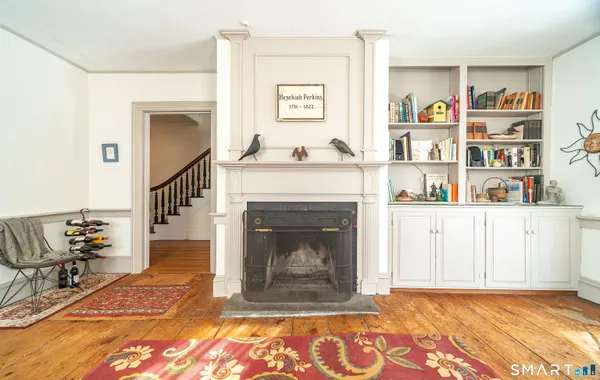 a living room with a fireplace and a book shelf