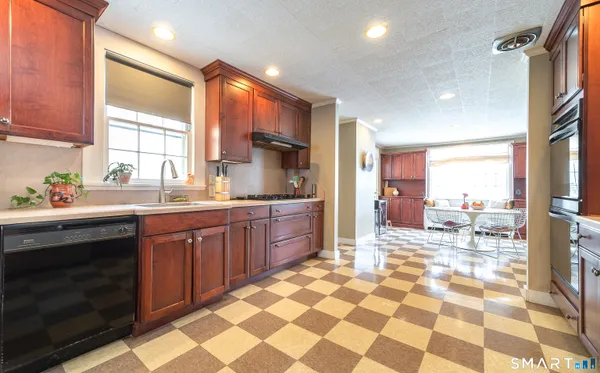 a large kitchen with stainless steel appliances a sink a stove a counter top space and a window