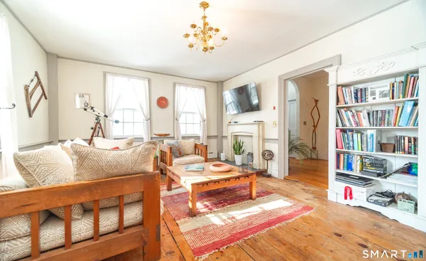 a living room with furniture a bookshelf and a window
