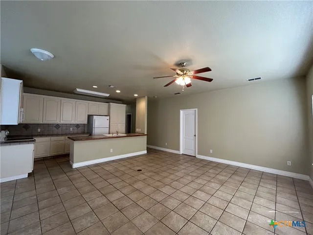 a view of kitchen with granite countertop cabinets and window