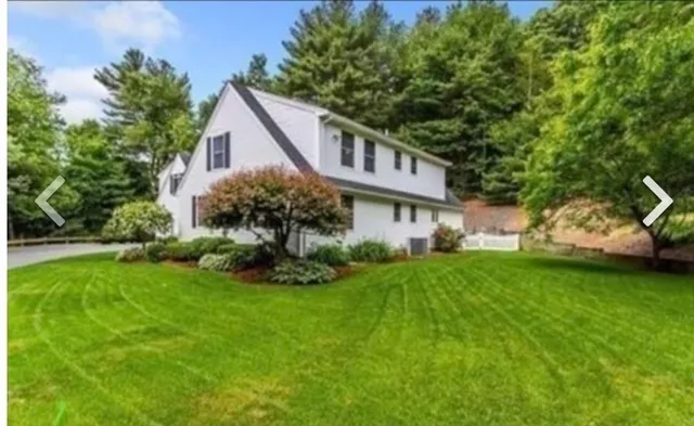 a view of a house with a big yard plants and large trees