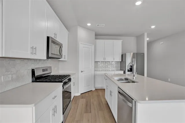 a kitchen with stainless steel appliances granite countertop a sink stove and refrigerator