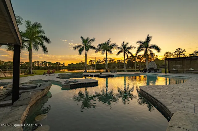 a dining room with furniture water view and a floor to ceiling window