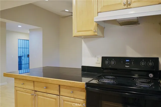 a kitchen with granite countertop stove and cabinets