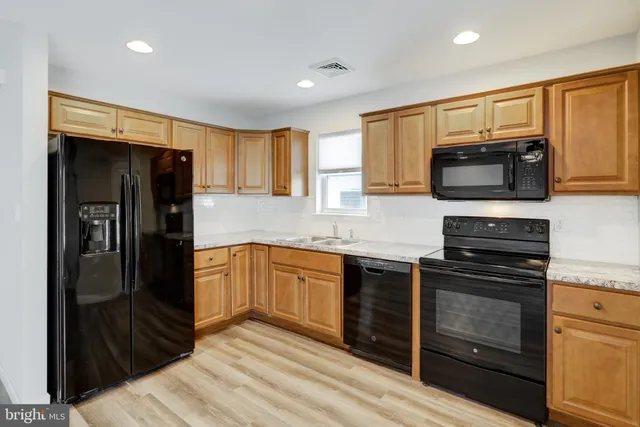 a kitchen with granite countertop a refrigerator stove and microwave