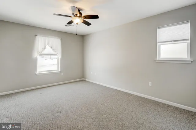 an empty room with chandelier fan