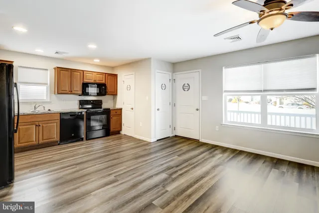 a view of kitchen with stainless steel appliances granite countertop a stove top oven a sink and a microwave