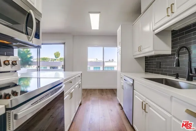 a kitchen with stainless steel appliances a sink and stove