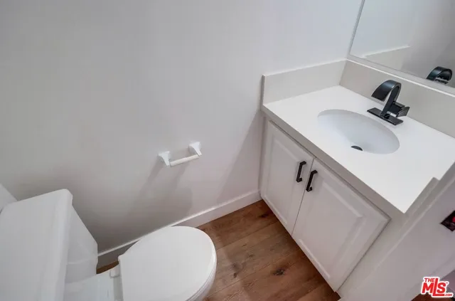 a view of a big room with wooden floor and windows