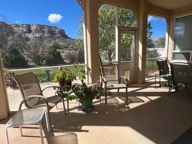 a view of a patio with table and chairs with wooden floor and fence