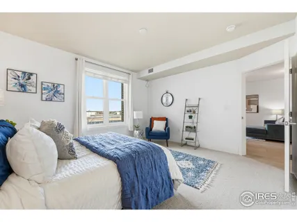 a bedroom with a bed a mirror and furniture