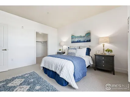 a bedroom with a bed and a painting on the wall