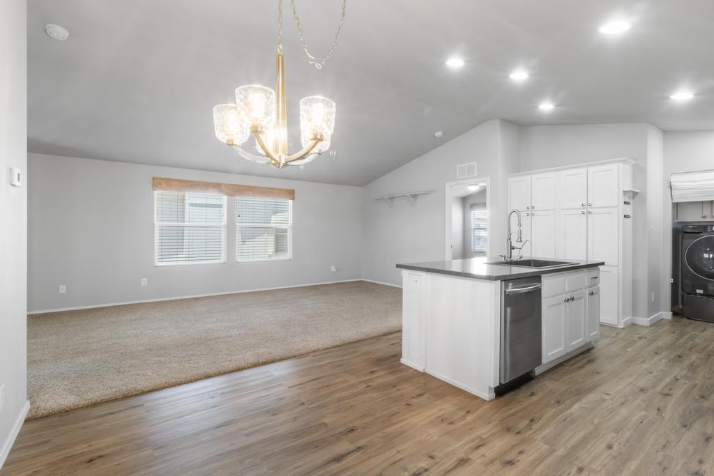1545 East El Rodeo Road, Unit 42 Fort Mohave, AZ 86426 - Photo 20 of 45 a kitchen with stainless steel appliances granite countertop a stove a sink dishwasher and a refrigerator with wooden floor
