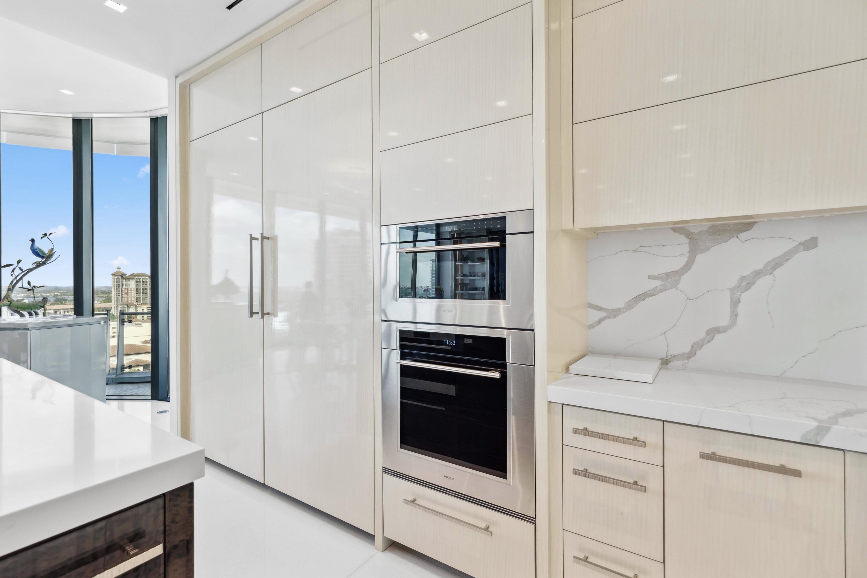 1100 South Flagler Drive, Unit 1801 West Palm Beach, FL 33401 - Photo 13 of 56 a kitchen with stainless steel appliances white cabinets and a refrigerator