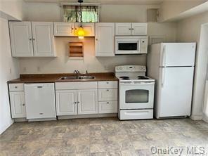 150 Brandt Road, Unit 150C Westbrookville, NY 12785 - Photo 1 of 1 a kitchen with granite countertop white cabinets and white appliances