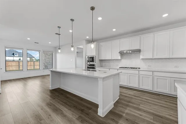 a kitchen with kitchen island a sink stainless steel appliances and cabinets