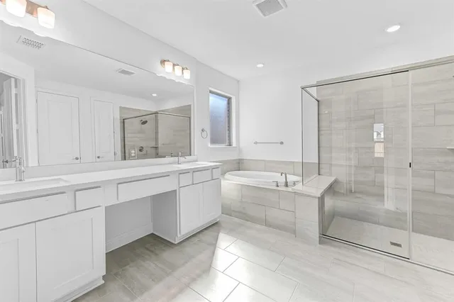 a large bathroom with a double vanity sink mirror and bathtub