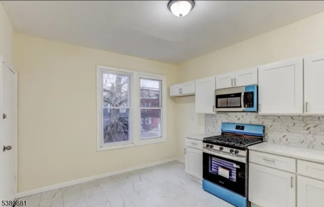 a kitchen with stainless steel appliances white cabinets and a stove top oven