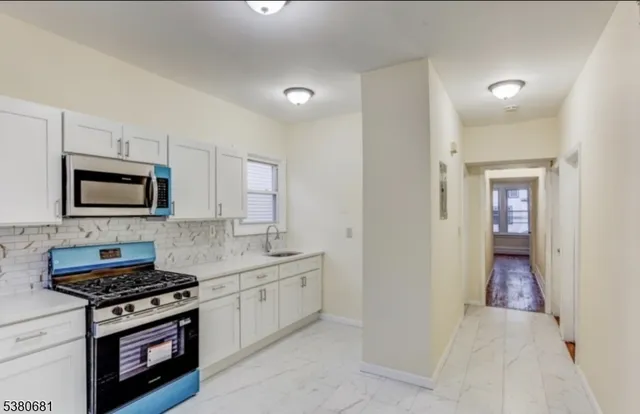 a kitchen with stainless steel appliances a sink dishwasher a stove and a microwave