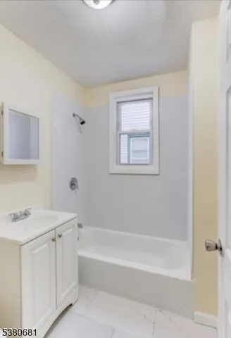 a white bath tub sitting next to a white sink