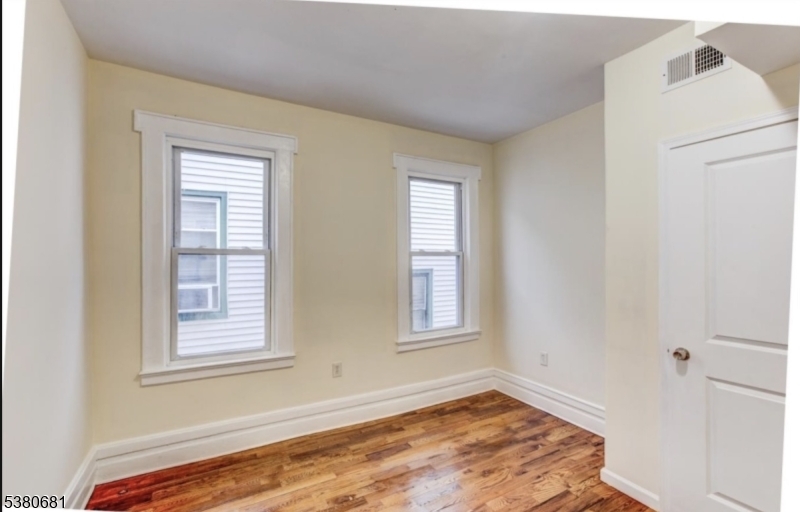 277 Wainwright Street Newark, NJ 07112 - Photo 10 of 11 a view of an empty room with a window and wooden floor