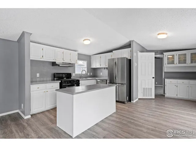 a kitchen with refrigerator a stove a microwave and cabinets