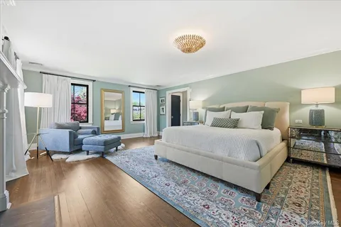 a bedroom with a large bed and wooden floor