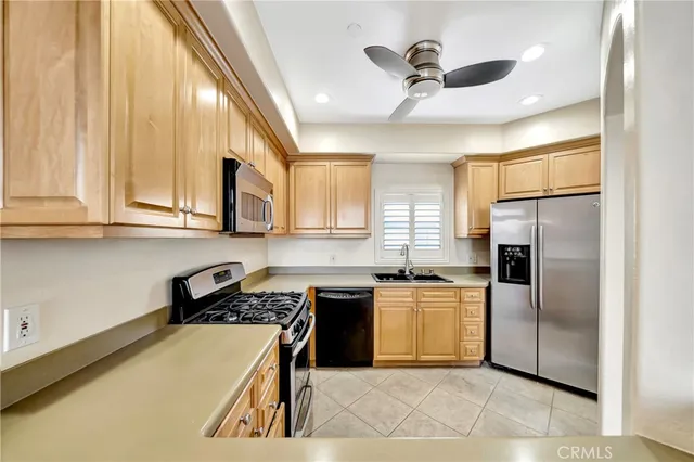 a kitchen with stainless steel appliances granite countertop a sink a stove and refrigerator