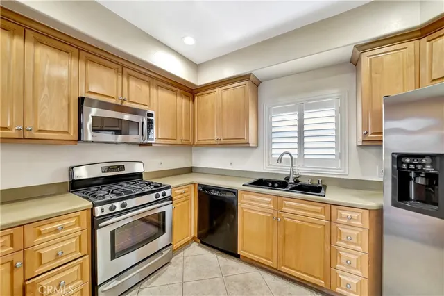 a kitchen with granite countertop cabinets stainless steel appliances a sink and a window