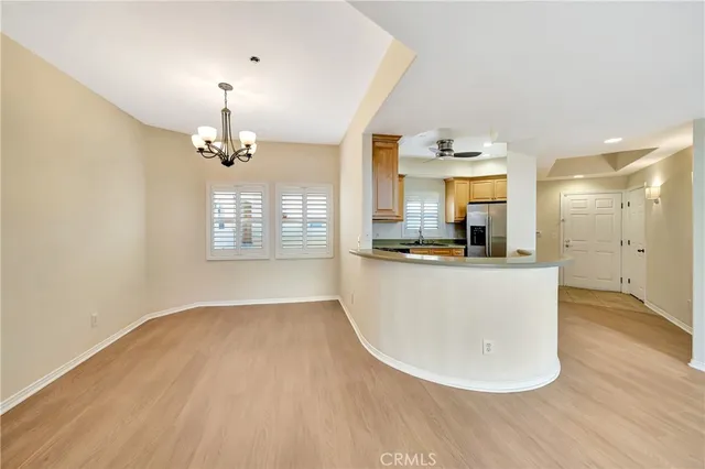 a view of a room with wooden floor and kitchen view