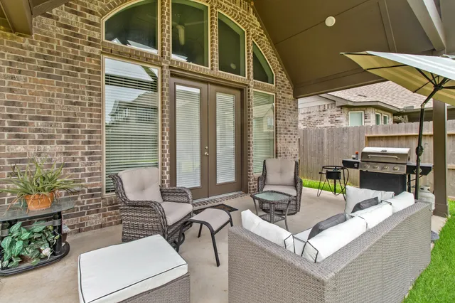 a view of a patio with couches table and chairs with potted plants