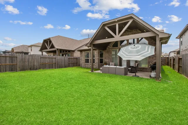 a view of a big house with a big yard and large trees