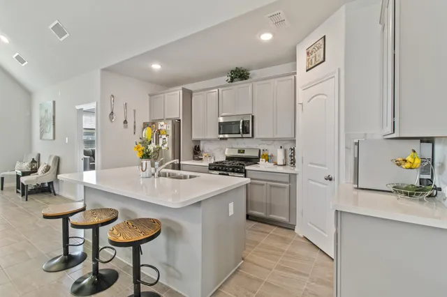 a kitchen with cabinets a sink and appliances