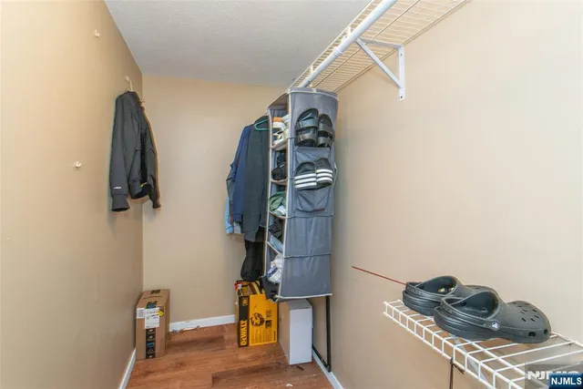 a view of walk in closet with clothes and shoes