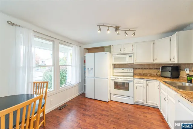 a kitchen with granite countertop a stove top oven sink and cabinets